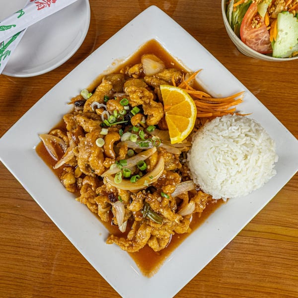 Thai Spice Lees Summit's cashew chicken with rice, orange slice, and a side salad.